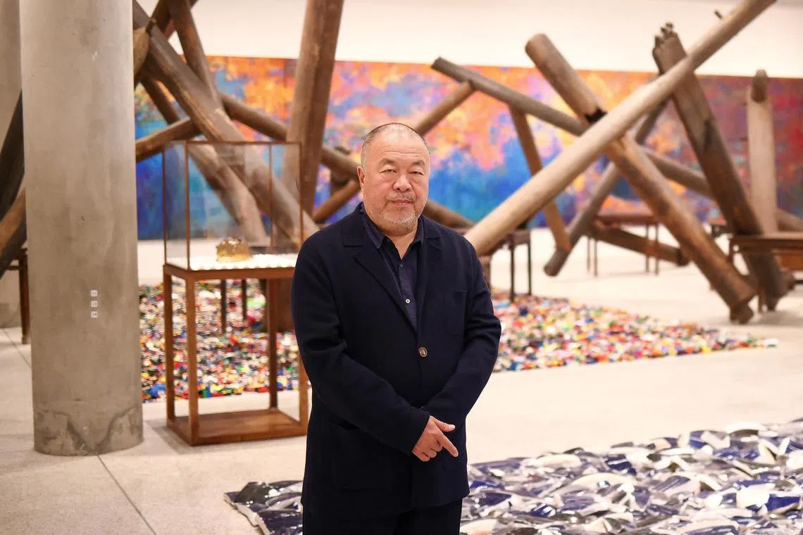 Chinese artist Ai Weiwei poses during a photocall, amongst art pieces displayed in his exhibition Ai Weiwei: Making Sense at the Design Museum in London on April 4, 2023. 