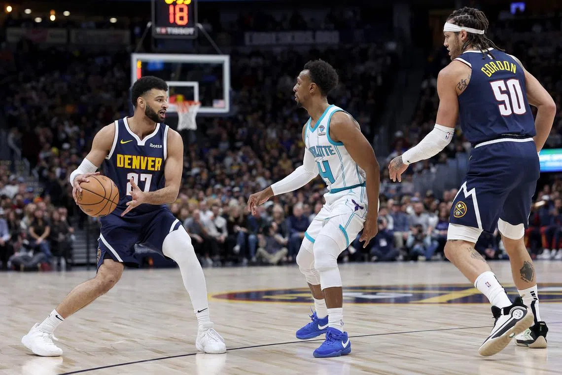 Jamal Murray of the Denver Nuggets is guarded by Ish Smith of the Charlotte Hornets in the first quarter at Ball Arena.
