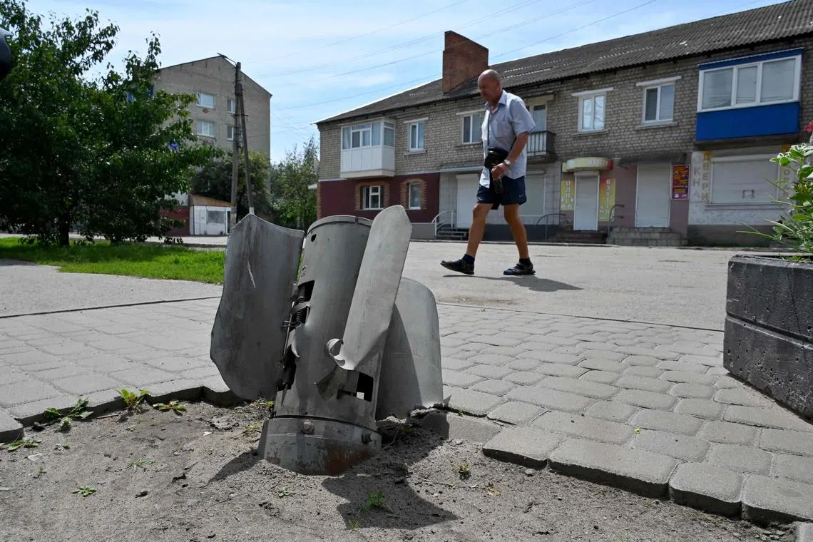 A man walks past the remains of a Russian missile in Ukraine's Kharkiv region.