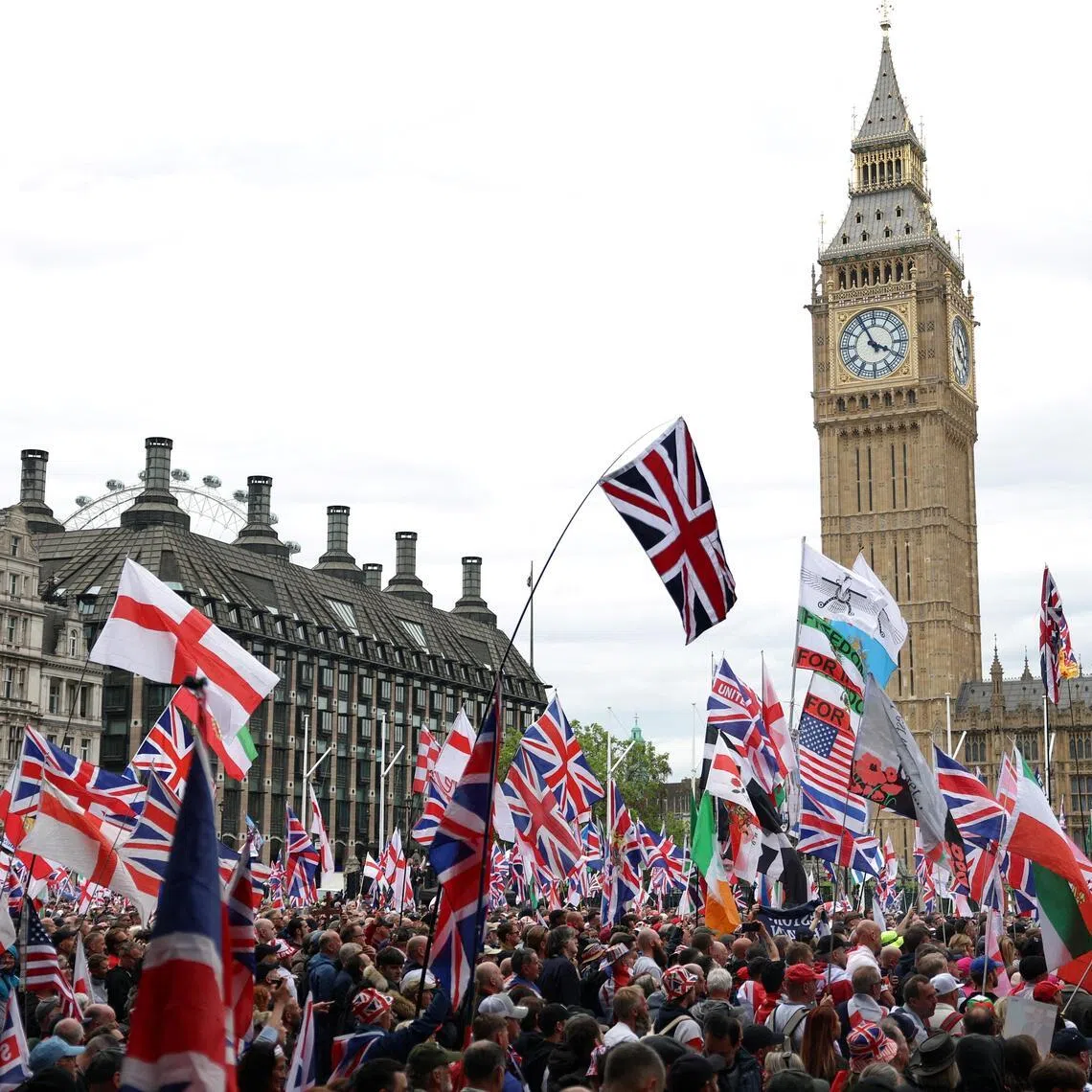 Pprotesters hold flags during a "Unite the Kingdom" rally organised by British anti-immigration activist Stephen Yaxley-Lennon, also known as Tommy Robinson, in London on May 16, 2026.  