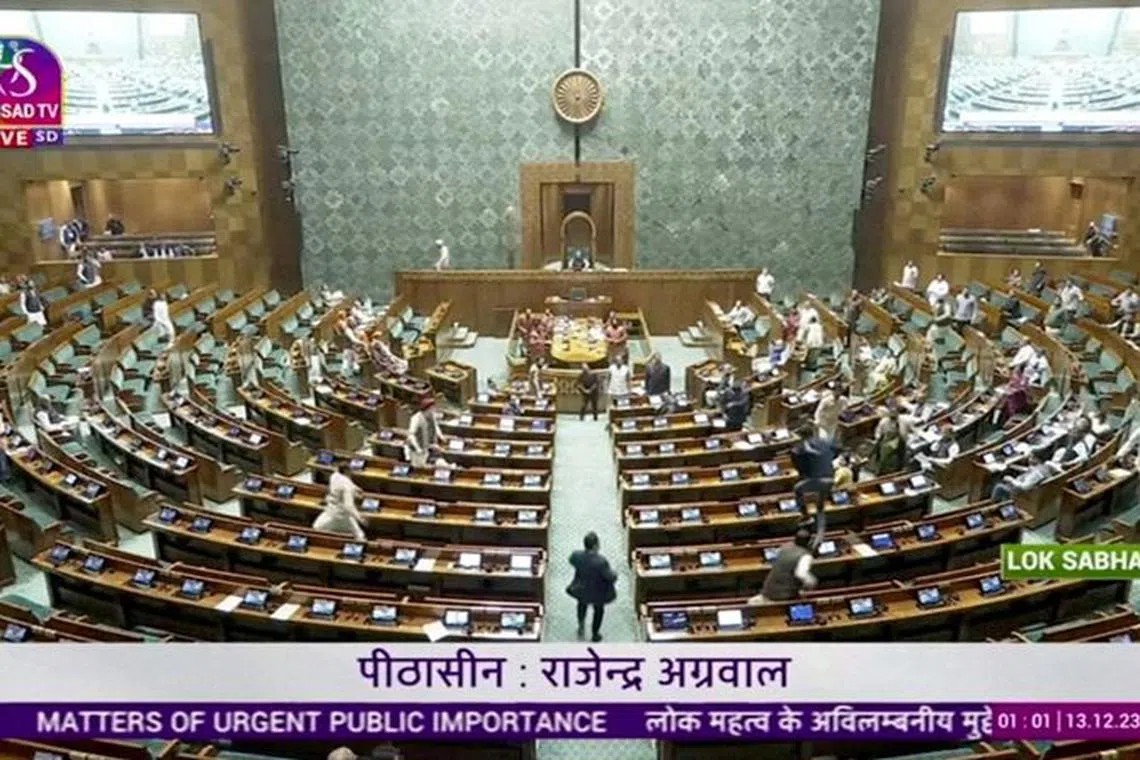 FILE PHOTO: A man jumps into the lawmakers' area in the lower house of the Indian Parliament, in New Delhi, India, December 13, 2023, in this screengrab obtained from a handout video. Sansad TV/Handout via REUTERS/File Photo