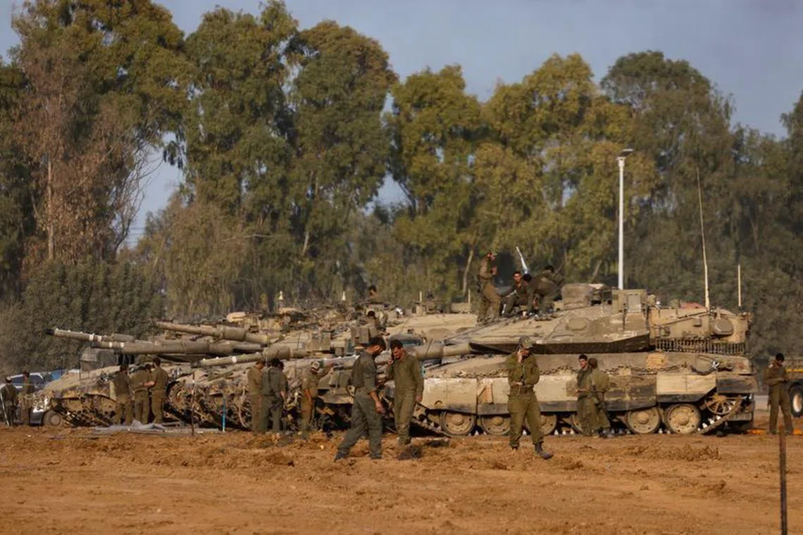 Israeli soldiers stand by tanks, after returning from the Israeli military's ongoing ground operation in Gaza, amid the conflict between Israel and the Palestinian Islamist group Hamas, near the Israel-Gaza border, in Israel, December 30, 2023. REUTERS/Amir Cohen