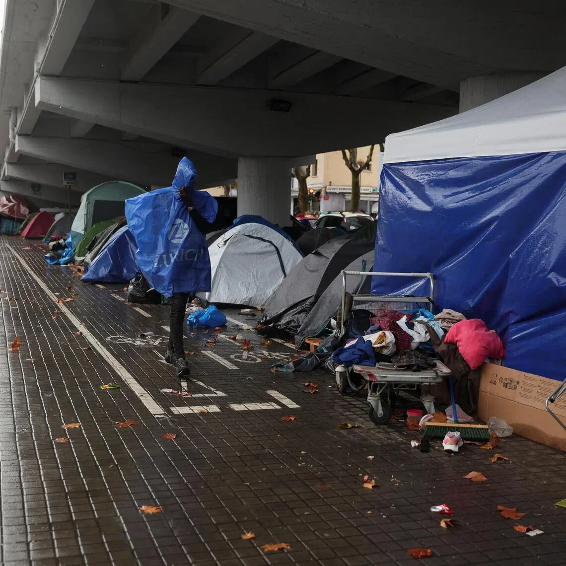 A migrant walking past a makeshift camp in Badalona, Spain, on Dec 26, after migrants were evicted from a former high school.