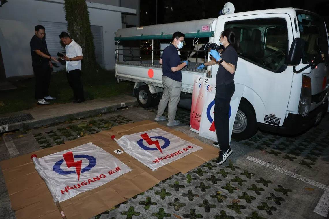 Members of the Singapore Police Force seen taking evidential photographs of vandalised PAP flags in the early hours of May 4.