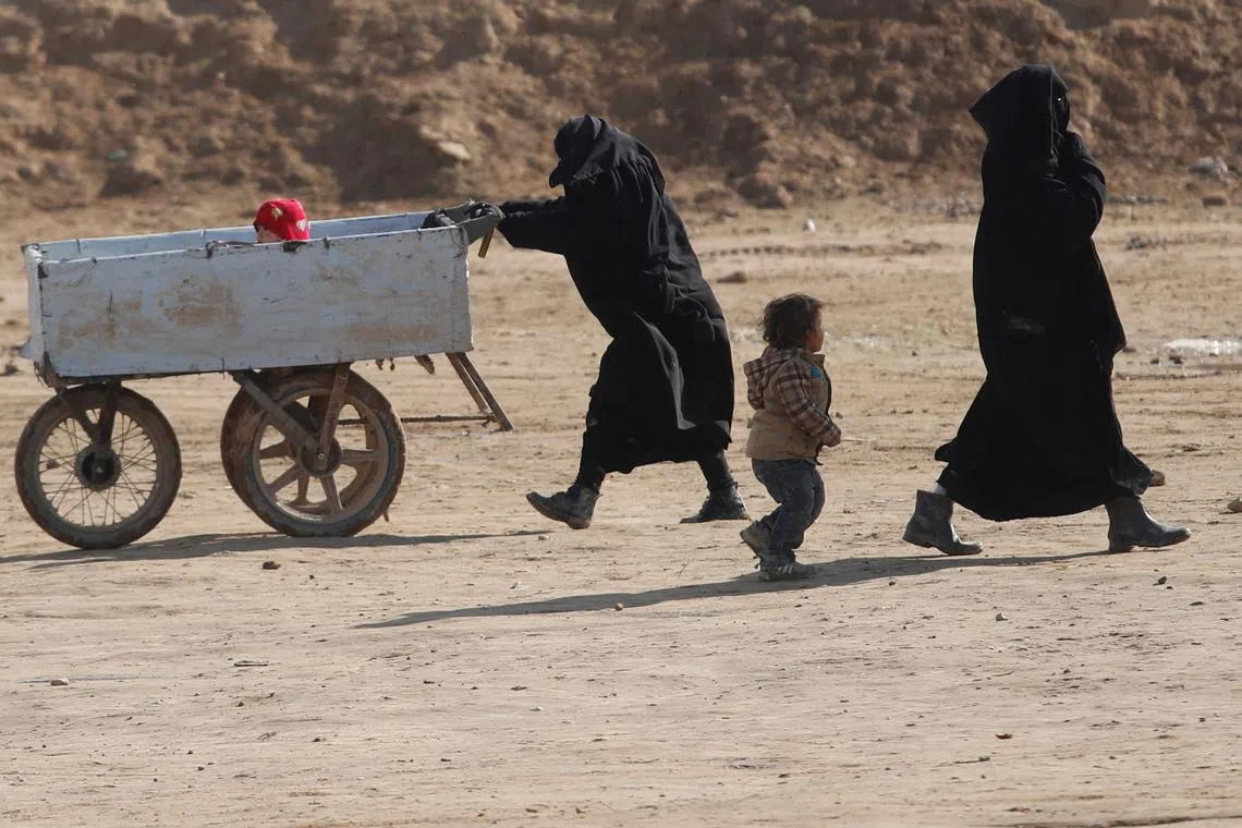 FILE PHOTO: Women and children walk through al-Hol camp in Syria, January 8, 2020. Picture taken, January 8, 2020. REUTERS/Goran Tomasevic/File Photo