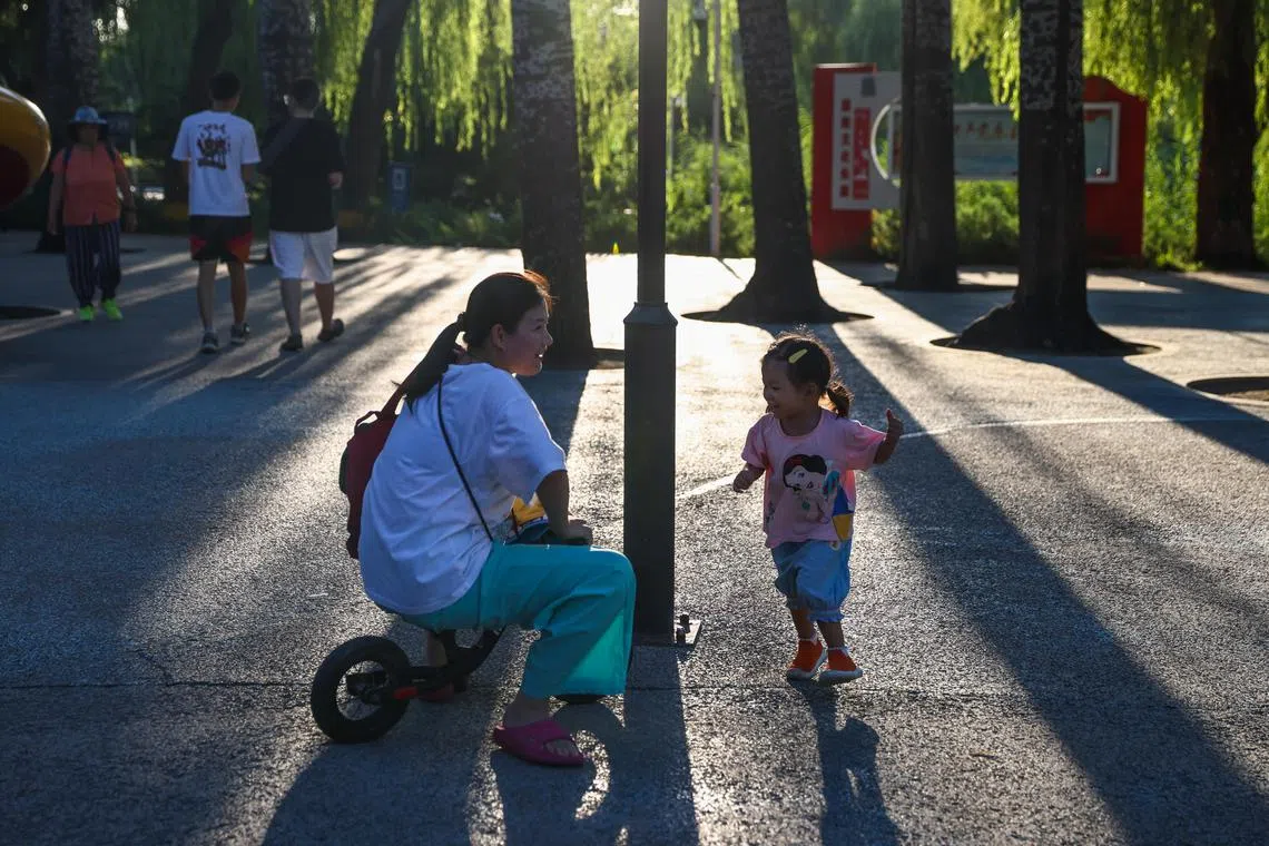 epa12272513 A woman plays with a child in a park in Beijing, China, 30 July 2025. On July 30, China’s Ministry of Finance announced that it will allocate 90 billion yuan (10.85 billion euros) for the initial budget of childcare subsidy payments in 2025.  EPA/WU HAO