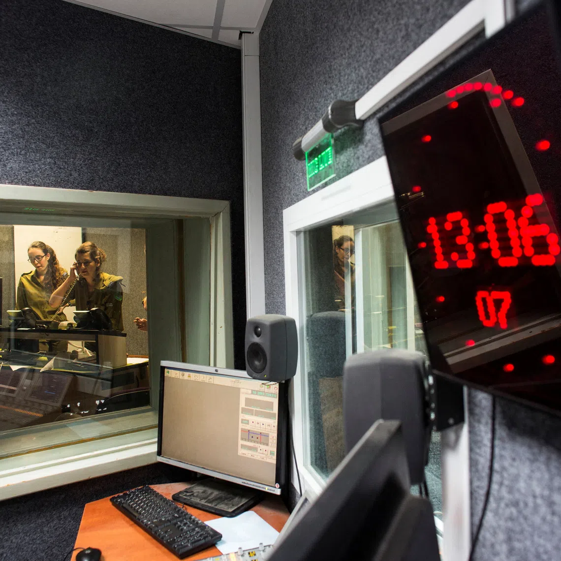 FILE PHOTO: Israeli soldiers from Galei Tzahal, the Israeli army radio station, are seen through a window while producing a show at the station's studio in Jaffa, south of central Tel Aviv November 10, 2013. REUTERS/Nir Elias/File Photo