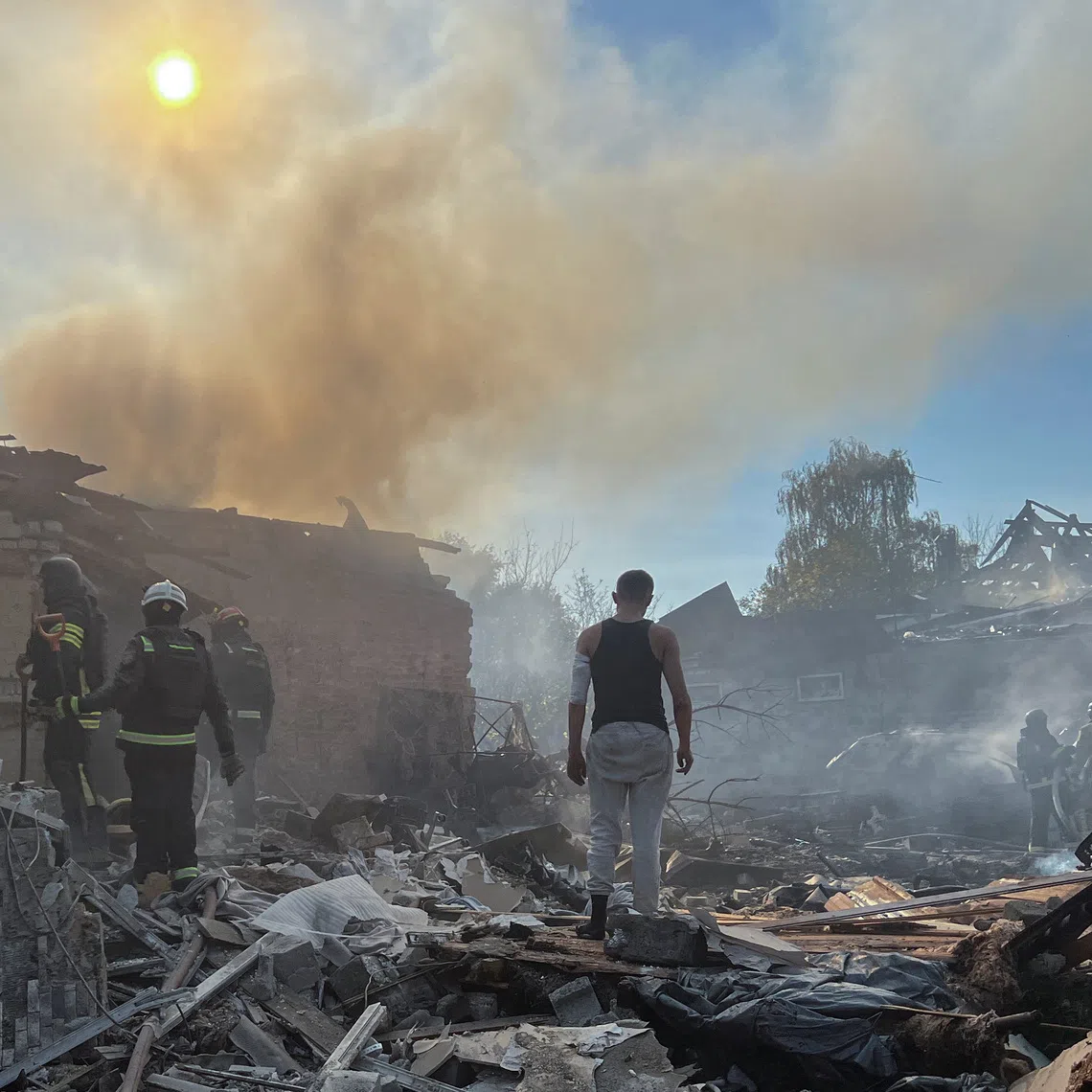An injured man stands amid rubble as firefighters work at the site of his house hit by a Russian air strike, amid Russia's attack on Ukraine, in Kharkiv, Ukraine October 11, 2026. Picture taken with a mobile phone. REUTERS/Volodymyr Pavlov