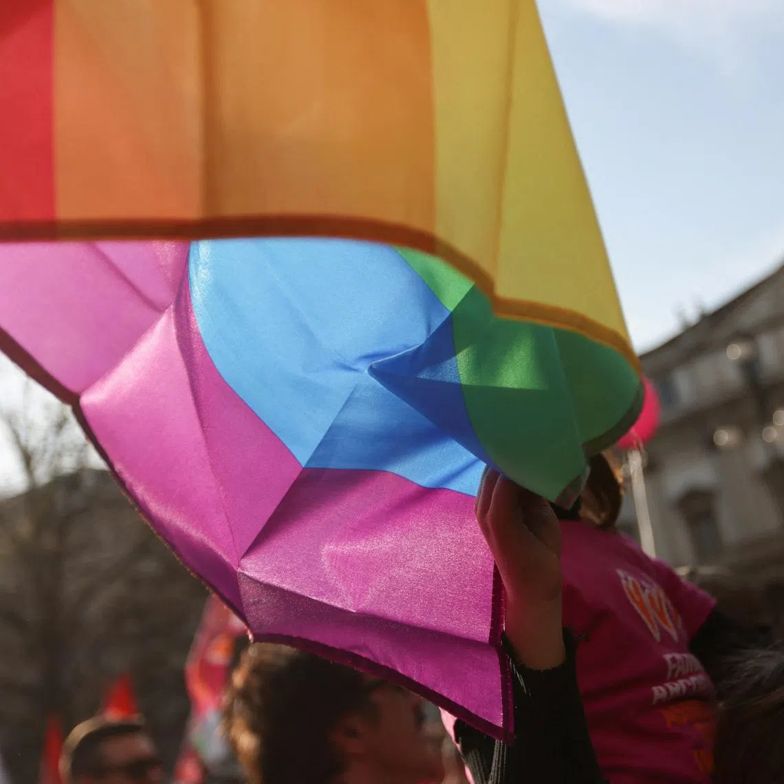 A child of a same-sex couple touches the LGBT flag at a protest after Italy's right-wing government told Milan's city council to stop registering same-sex parents' children in Milan, Italy March 18, 2023. REUTERS/Claudia Greco