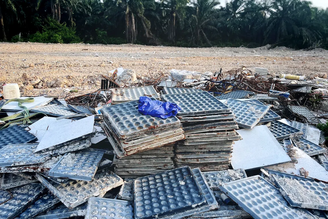 Broken tiles, cement scraps, rubber hoses, metal bars and construction equipment such as cement buckets and helmets can be seen at the sites.