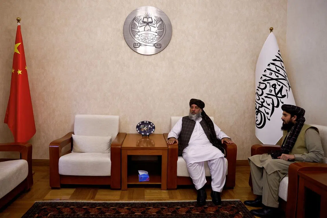 FILE PHOTO: Taliban's acting commerce minister Haji Nooruddin Azizi sits next to flags of the Islamic Emirate of Afghanistan and China, during an interview with Reuters, at the Embassy of Afghanistan in Beijing, China October 19, 2023. REUTERS/Tingshu Wang/File Photo