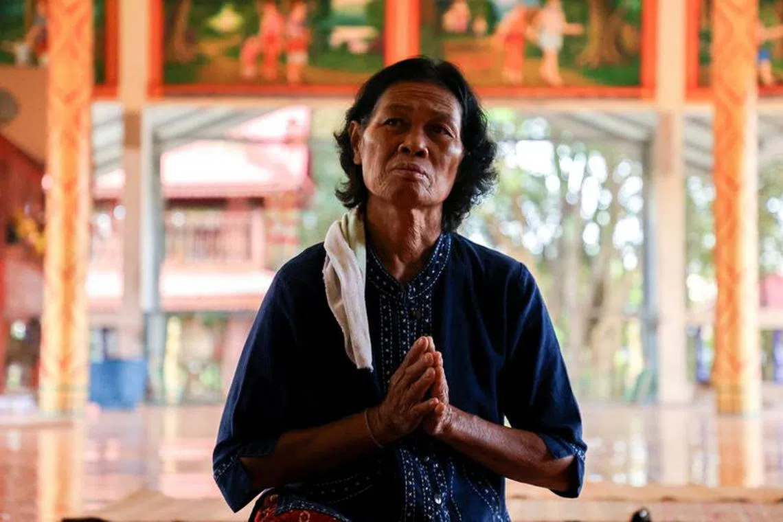 Noopar Pansa-ard, 63, prays for her son, Somkuan Pansa-ard, 39, a Thai labour who was killed in Israel in the ongoing conflict between Israel and the Palestinian Islamist group Hamas, at a temple in Kalasin province, Thailand, October 11, 2023. REUTERS/Thomas Suen