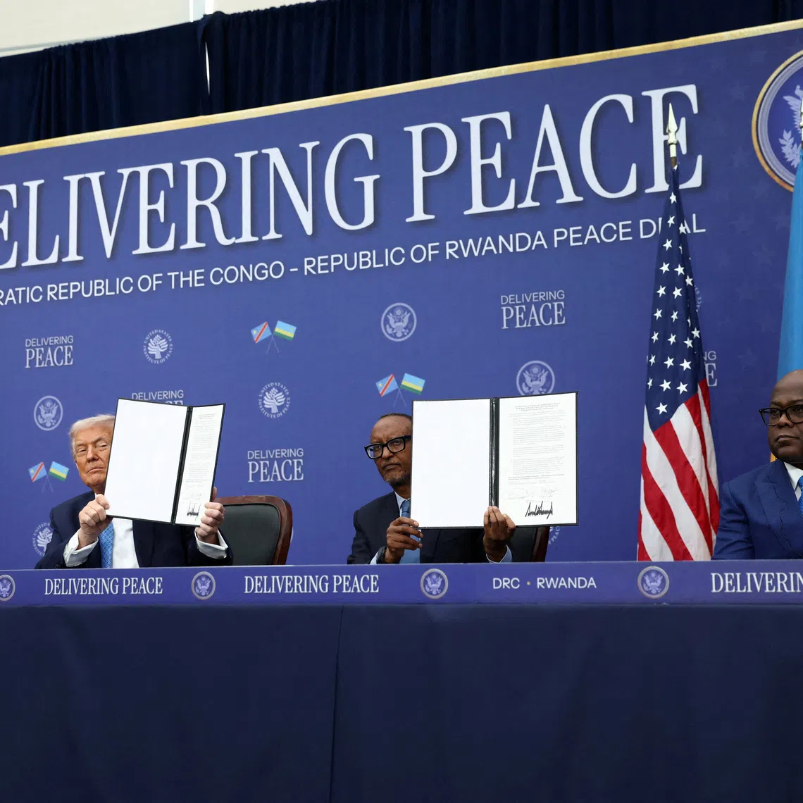 FILE PHOTO: U.S. President Donald Trump, President of the Democratic Republic of the Congo Felix Tshisekedi and President of Rwanda Paul Kagame hold a signed document during a signing ceremony at the U.S. Institute of Peace in Washington, D.C., U.S., December 4, 2025. REUTERS/Kevin Lamarque/File Photo