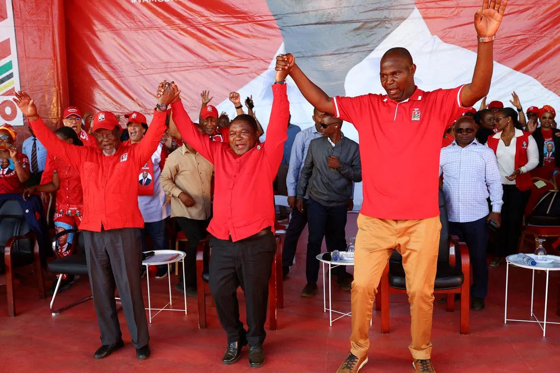 FILE PHOTO: Daniel Chapo, presidential candidate of the ruling Frelimo party, President of Mozambique Filipe Nyusi and former President of Mozambique Joaquim Chissano react during the final rally campaign ahead of the national election, in Matola, Mozambique October 6, 2024. REUTERS/Siphiwe Sibeko/File Photo