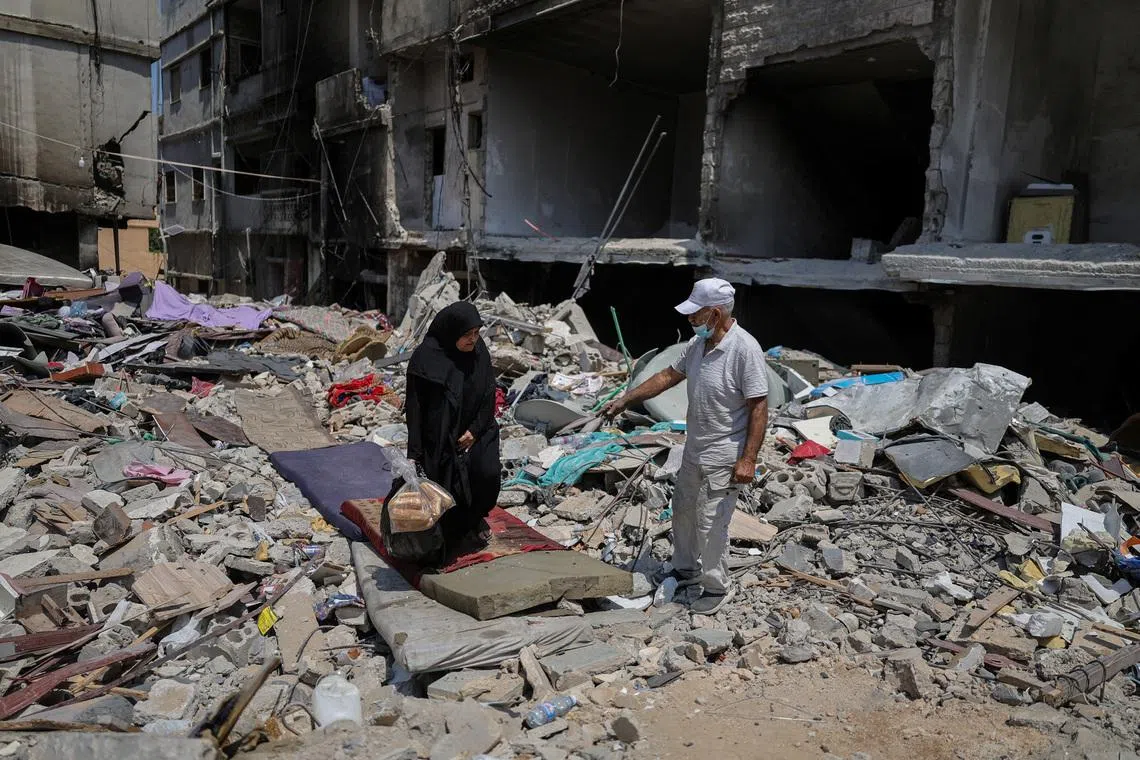Amira Hejazieh walks among the rubble of a building destroyed in an Israeli airstrike as she talks to her neighbor, after returning home following displacement during the war, after the Israel-Lebanon deal, in Tyre, southern Lebanon, July 5, 2026. REUTERS/Zohra Bensemra