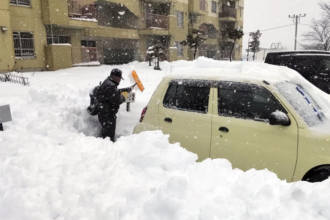 A man clears snow at a parking lot in Kitami, Hokkaido Prefecture, on Dec 24, 2022.