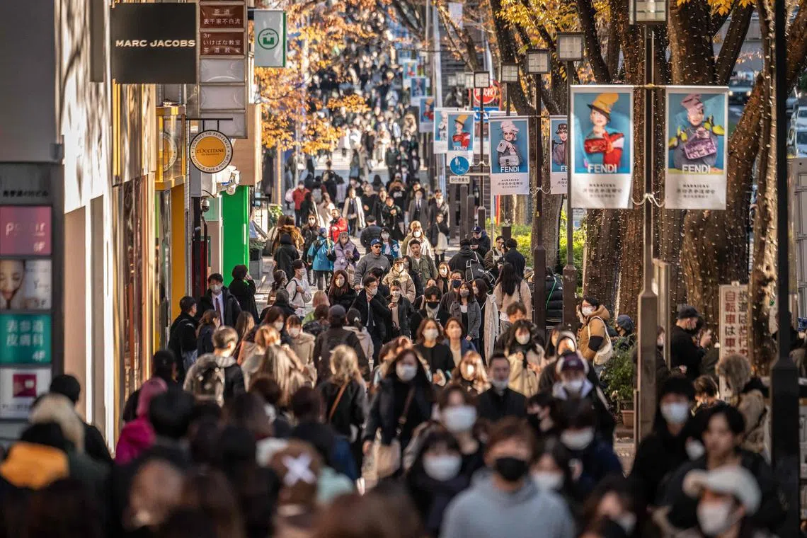 People walk through a shopping street in Omotesando, Tokyo on December 15, 2022.