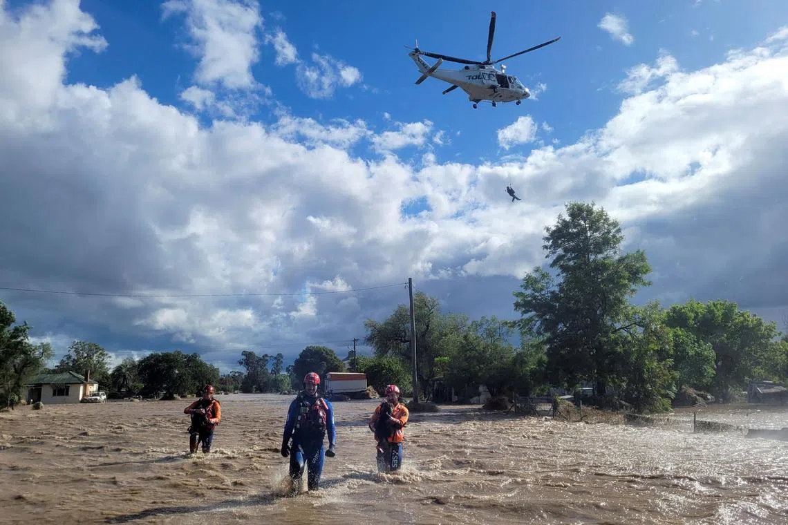 This handout photograph taken on Nov 14, 2022, and released by New South Wales State Emergency Service (SES) shows officials doing rescue work in the flooded towns around the overflowing Wyangala Dam near Cowra. 
