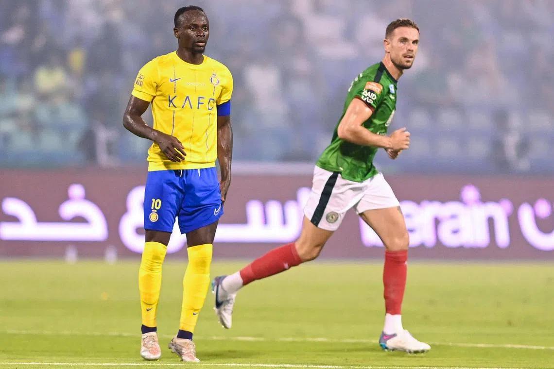 Al-Ettifaq captain Jordan Henderson running past Al-Nassr's Sadio Mane during their Saudi Pro League match in the Prince Mohamed bin Fahd Stadium in Dammam.