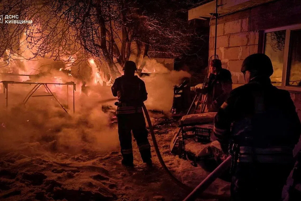 Firefighters work at the site of a residential household damaged during Russian drone and missile strikes, amid Russia's attack on Ukraine, in Kyiv region, Ukraine, January 13, 2026. Press service of the State Emergency Service of Ukraine in Kyiv region/Handout via REUTERS