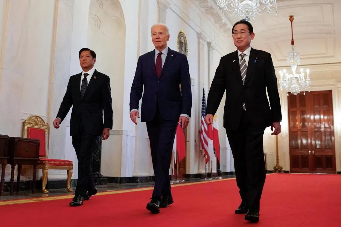 U.S. President Joe Biden escorts Philippines President Ferdinand Marcos Jr. and Japan Prime Minister Fumio Kishida to their trilateral summit at the White House in Washington, U.S., April 11, 2024.  REUTERS/Kevin Lamarque