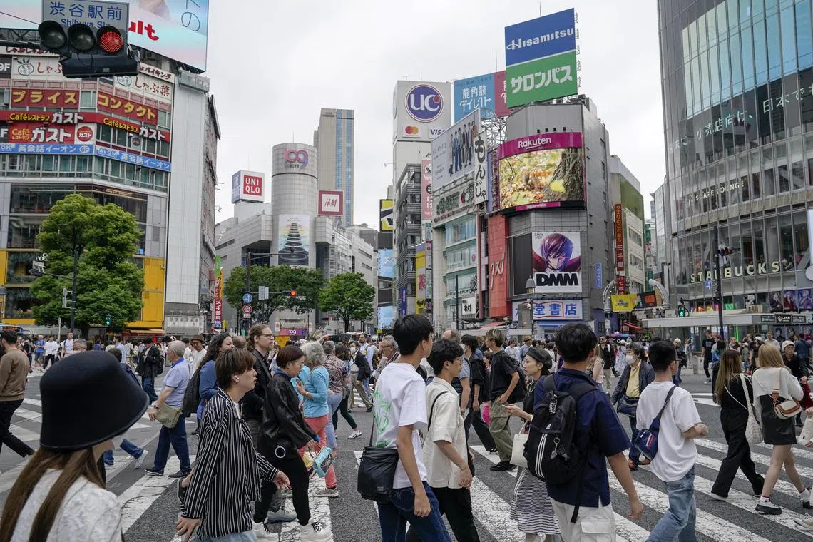 epa11344008 Pedestrians walk a scramble crossway at Shibuya in Tokyo, Japan, on May 16, 2024.