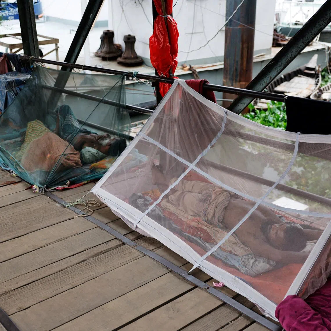 FILE PHOTO: People sleep using mosquito nets, following a surge of dengue-infected patients, in Dhaka, Bangladesh, June 25, 2025. REUTERS/Mohammad Ponir Hossain/File Photo
