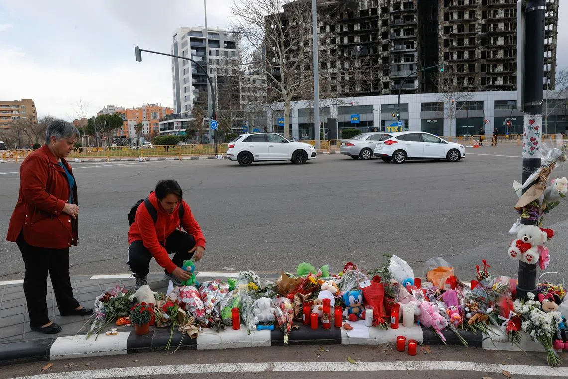 A man places a stuffed toy in a makeshift memorial near the building that caught fire on February 22 and resulted in several casualties, in Campanar neighbourhood, Valencia, Spain, February 26, 2024. REUTERS/Eva Manez