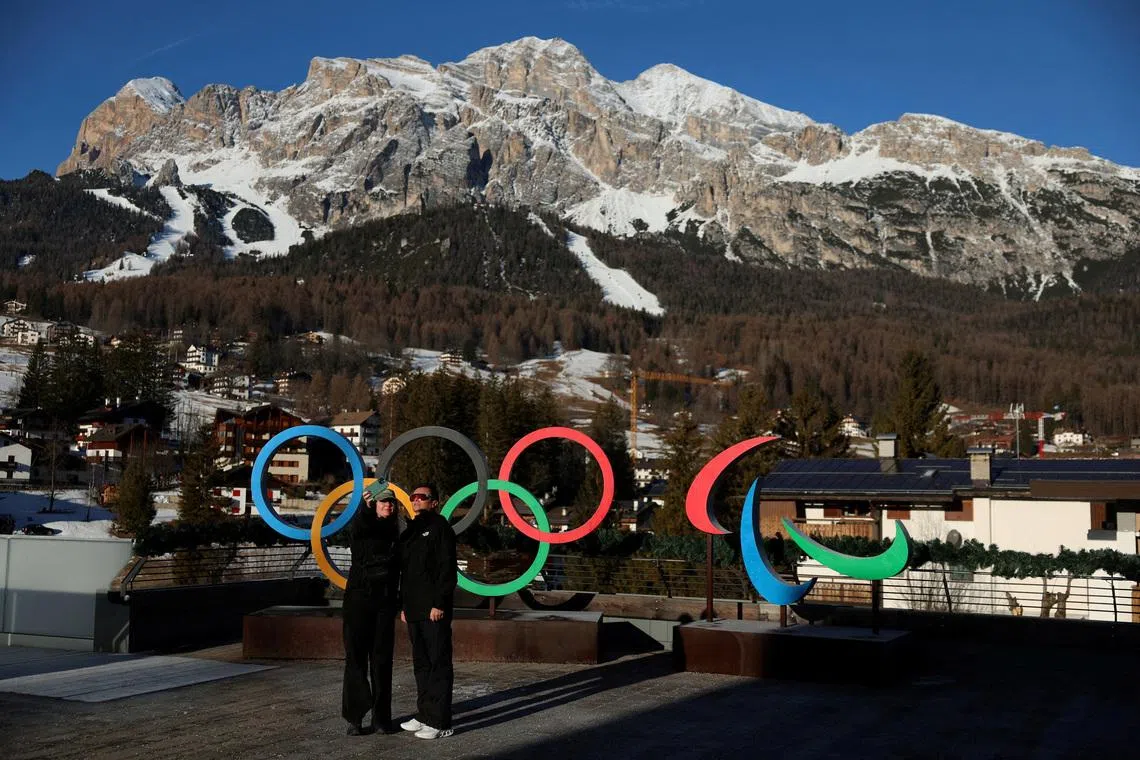 FILE PHOTO: People pose for a picture in front of the Olympic rings and the Olympia delle Tofane track, which will host the women's alpine skiing competition during the Milano Cortina Winter Olympic Games 2026, in Cortina, Italy, January 24, 2025. REUTERS/Claudia Greco/File Photo