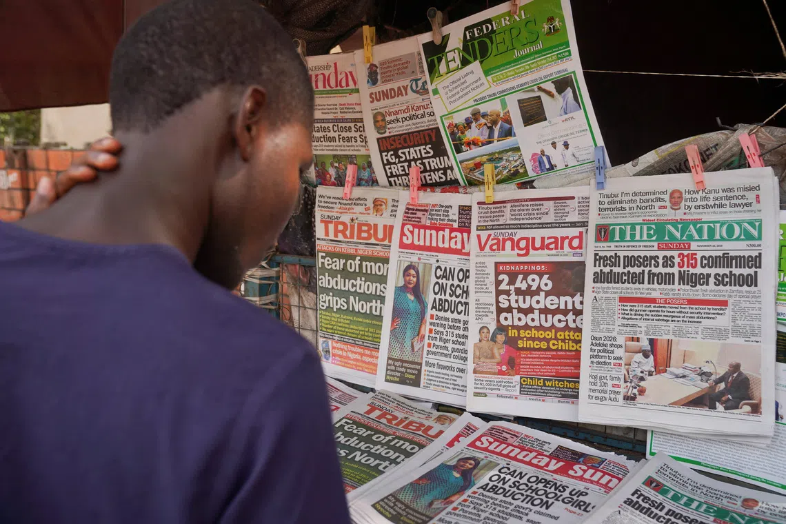 A person looks at newspapers with headlines on recent abductions at a stand in Area 1, Abuja, Nigeria, November 23, 2025. REUTERS/Marvellous Durowaiye