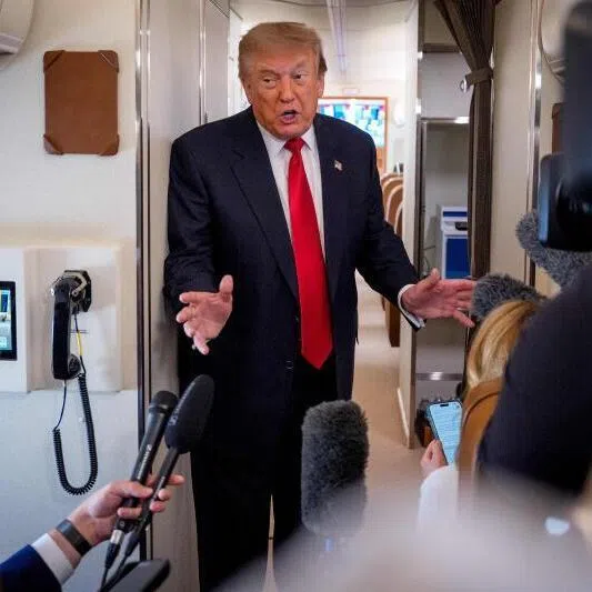 US President Donald Trump speaking aboard Air Force One en route to Michigan on July 27.