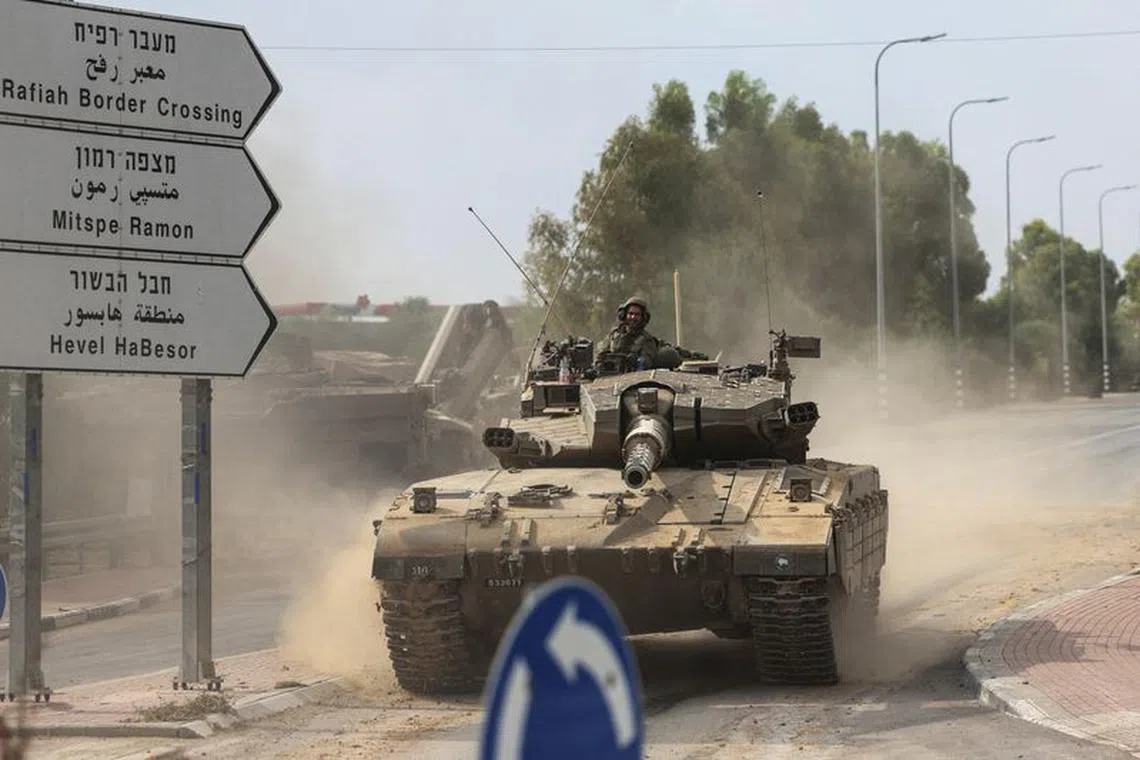 FILE PHOTO: Israeli soldiers drive in a tank by Israel's border with Gaza in southern Israel, October 10, 2023. REUTERS/Ronen Zvulun/File Photo