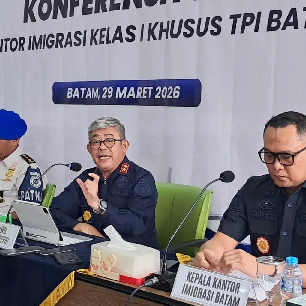 Immigration Directorate General Riau Islands Regional Office Head Ujo Sujoto (center) speaks while flanked by Batam Immigration Office Hajar Aswad (right) and an official from Internal Compliance Directorate Washington Napitupulu (left) on March 29, 2026, during a press conference at Batu Ampar Immigration checkpoint in Batam, Riau Islands. Ujo admitted there had been illegal levies and extortion practices at the Batam Center ferry terminal and promised severe punishment for those involved.