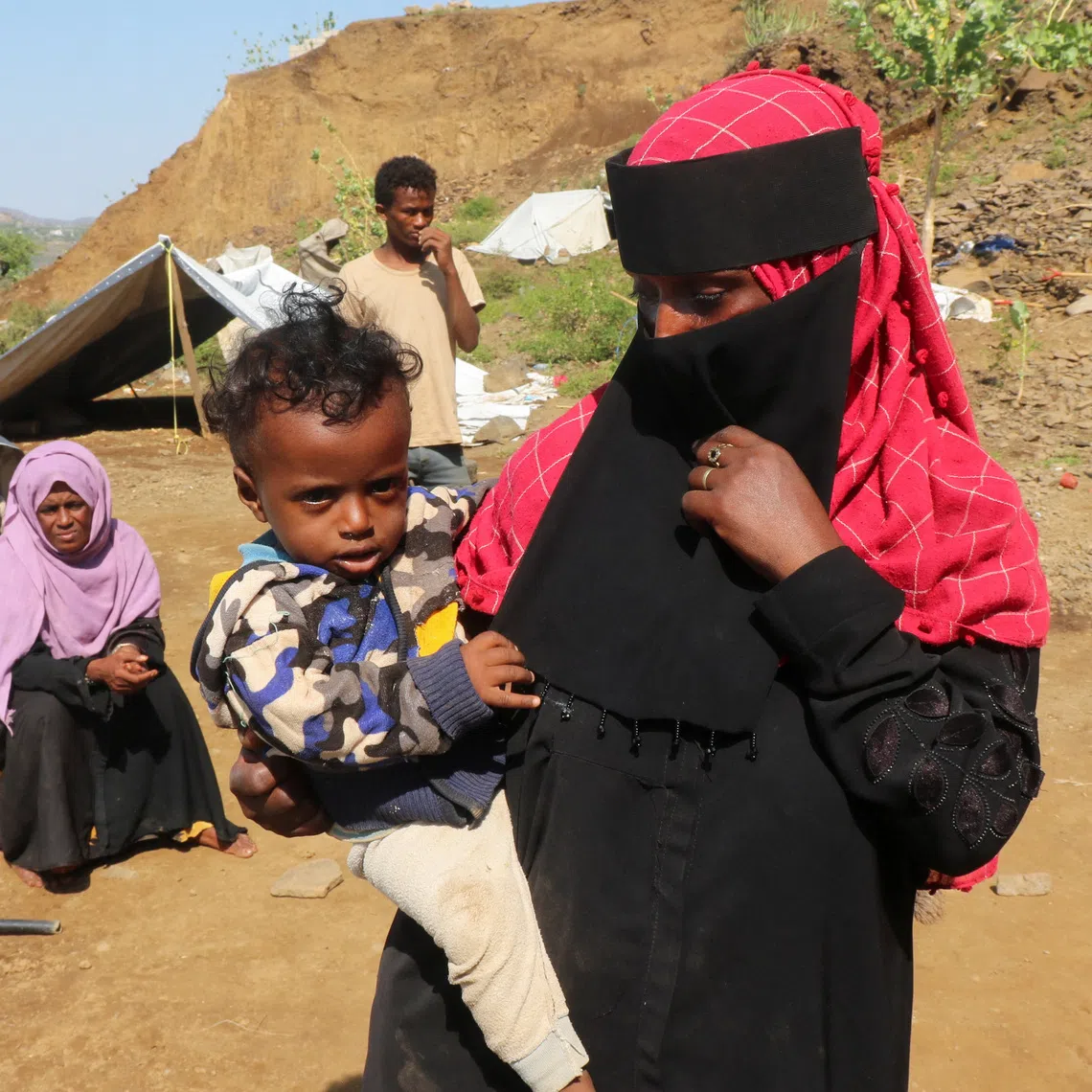 A displaced woman holding a child at a makeshift camp in Yemen’s Taiz province on Sept 21.