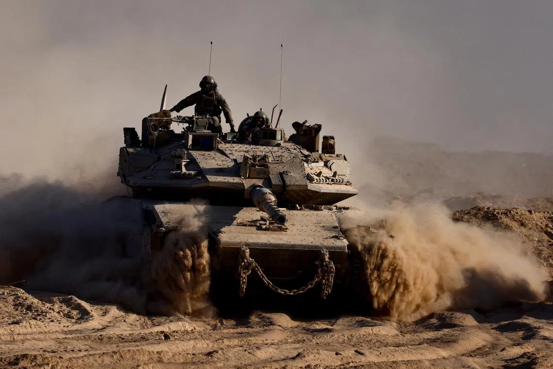 FILE PHOTO: An Israeli tank manouvres at the Israel-Gaza border, as seen from Israel, August 26, 2025. REUTERS/Amir Cohen/File Photo