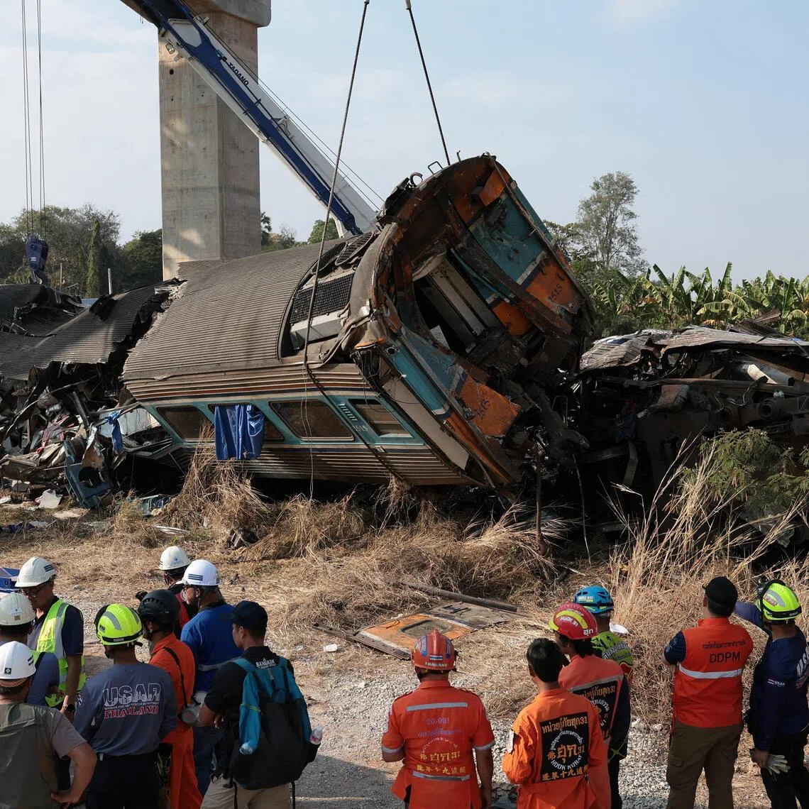 Rescue officials work at the site where a train was derailed when a construction crane collapsed and fell onto its carriages, causing several casualties, in Sikhio district, Nakhon Ratchasima province, Thailand, January 14, 2026. REUTERS/Chalinee Thirasupa
