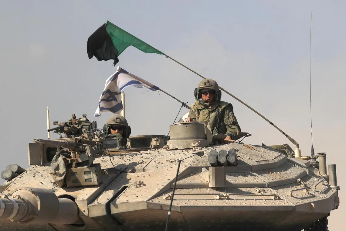 A Merkava battle tank carrying Israeli soldiers at an area along the border with Gaza, southern Israel.
