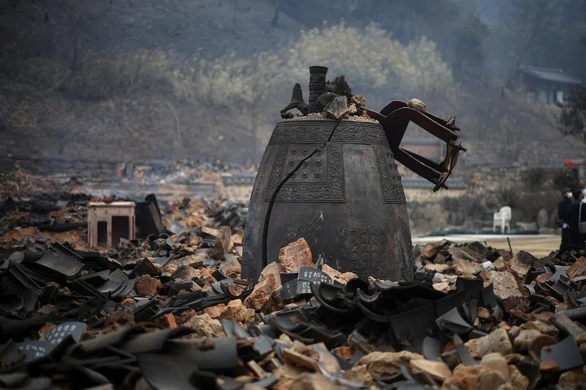 A damaged temple bell lies amidst debris at Gounsa temple after a wildfire devastated the area in Uiseong, South Korea, on March 27, 2025.