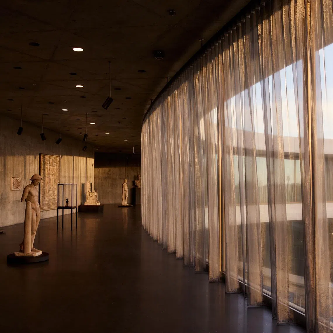 Works by one of the museum's walls of windows, shielded from light damage by sheer curtains.