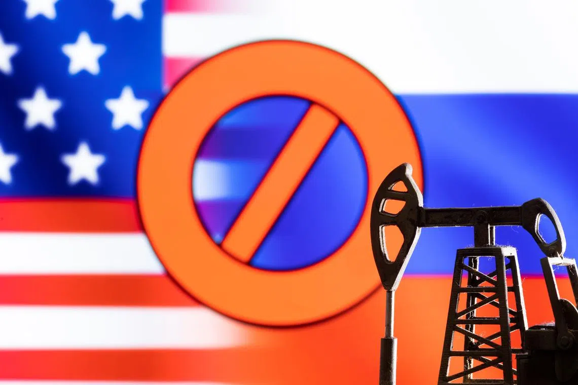 FILE PHOTO: A model of a pump jack is seen in front of the displayed sign \"stop\",  U.S. and Russia flag colours in this illustration taken March 8, 2022. REUTERS/Dado Ruvic/Illustration/File Photo