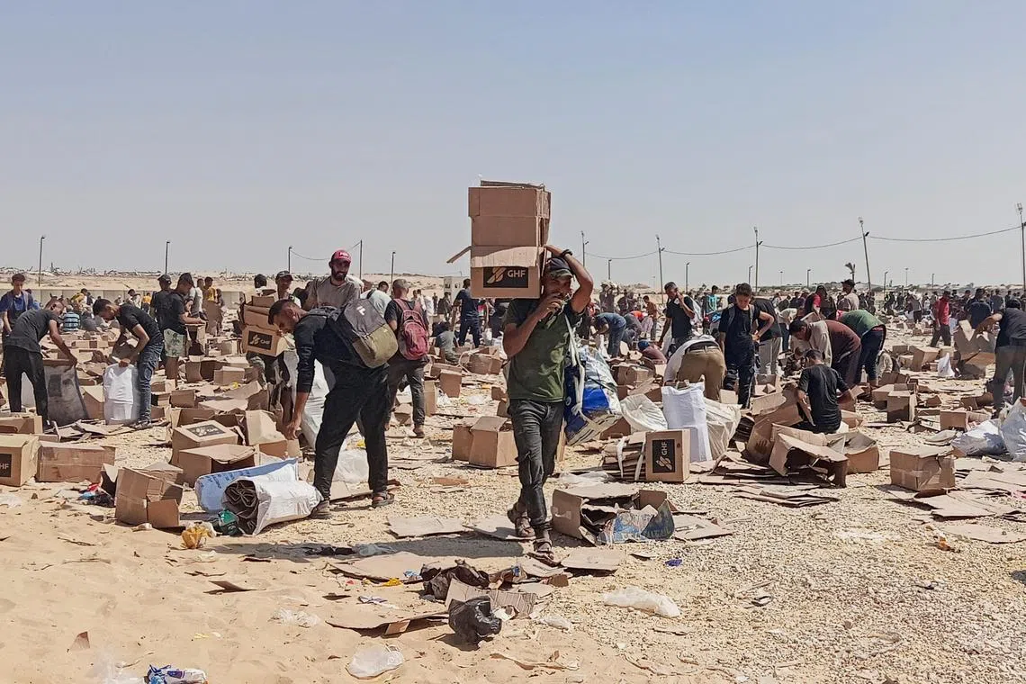 Palestinians collect what remains of relief supplies from the distribution centre of the US-backed Gaza Humanitarian Foundation, in Rafah, in the southern Gaza Strip, on June 5, 2025. 