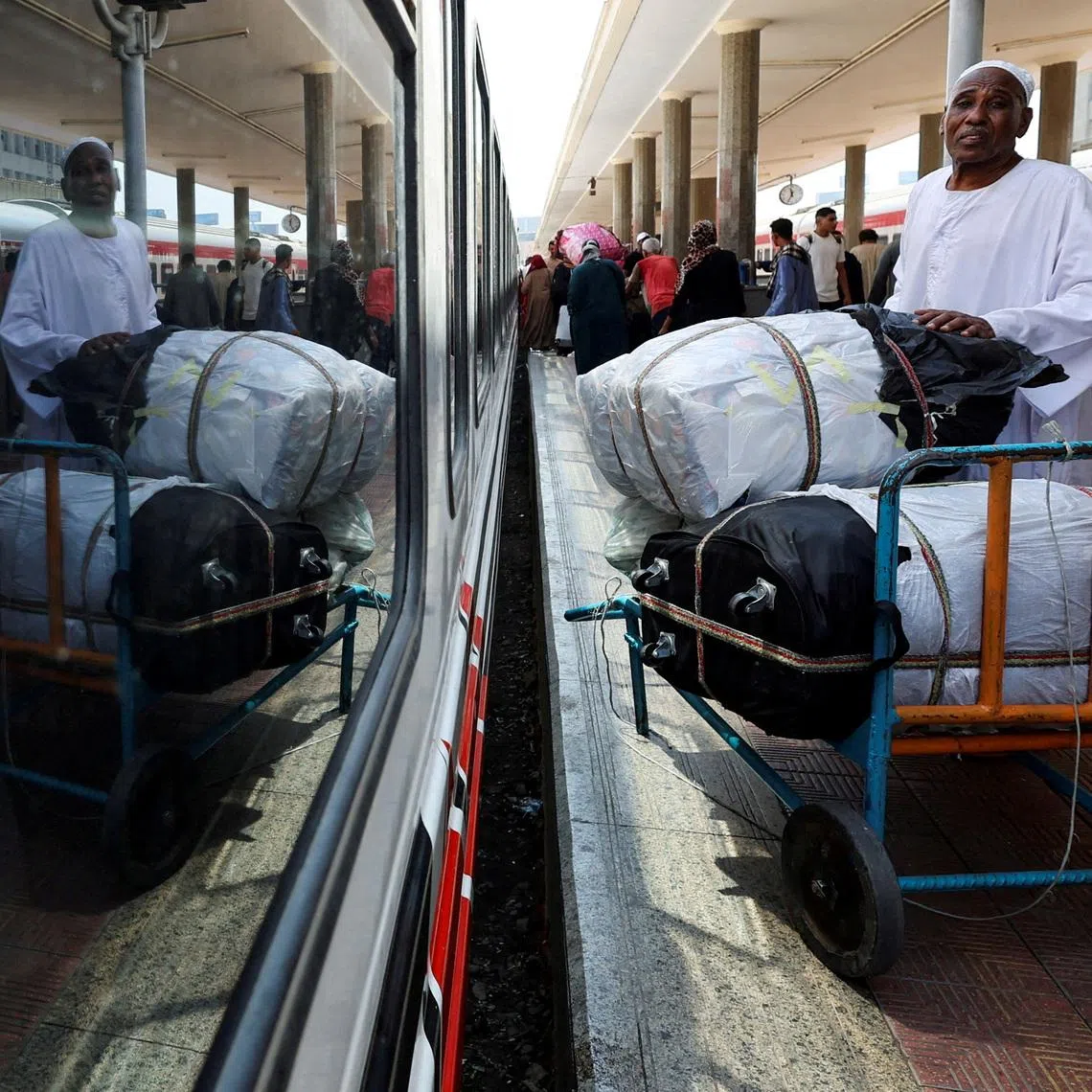 FILE PHOTO: A Sudanese man waits next to his luggage, as Sudanese refugee families crowd at Cairo's main station to board a free train with a voluntary return coordinated by the Egyptian government to Aswan, where buses take home to Khartoum, in Cairo, Egypt July 28, 2025. REUTERS/Amr Abdallah Dalsh/File Photo