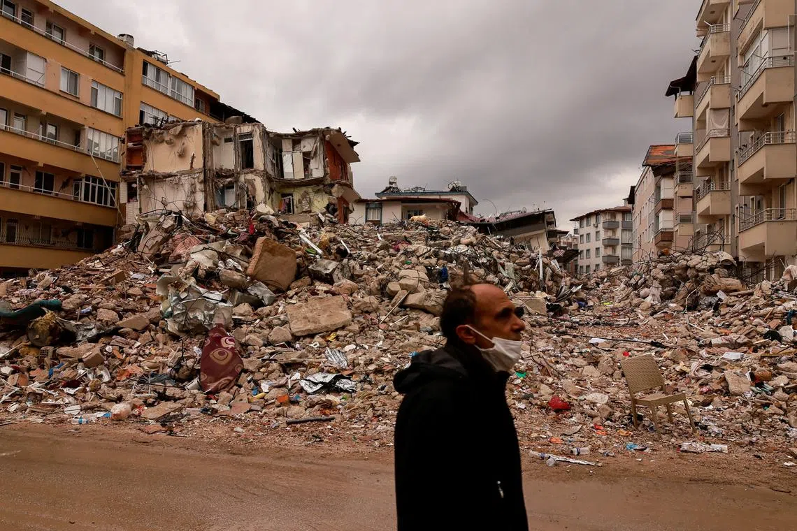 A man walking past destroyed properties in Antakya, Turkey, on Feb 21, 2023. 