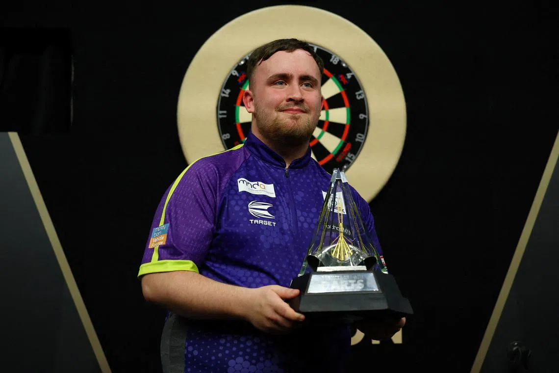 FILE PHOTO: Darts - 2024 Premier League - Play-Offs - London - The O2, London, Britain - May 23, 2024 Luke Littler celebrates with a trophy after winning his final match against Luke Humphries Action Images via REUTERS/Matthew Childs