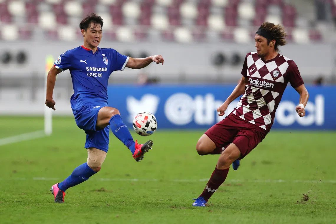 Soccer Football - AFC Champions League - Group G - Vissel Kobe v Suwon Bluewings - Khalifa International Stadium, Doha, Qatar - December 4, 2020  Suwon Bluewings' Gun-Hee Kim in action with Vissel Kobe's Ryuho Kikuchi REUTERS/Ibraheem Al Omari