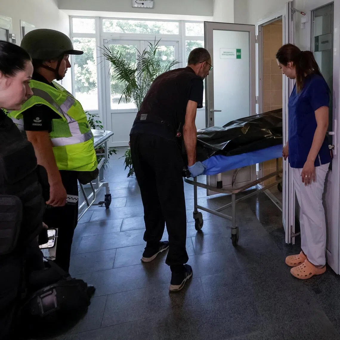 A worker carries the body of a person killed during a Russian air strike at a hospital amid Russia’s attack on Ukraine, in Kharkiv, Ukraine, on July 1, 2026.