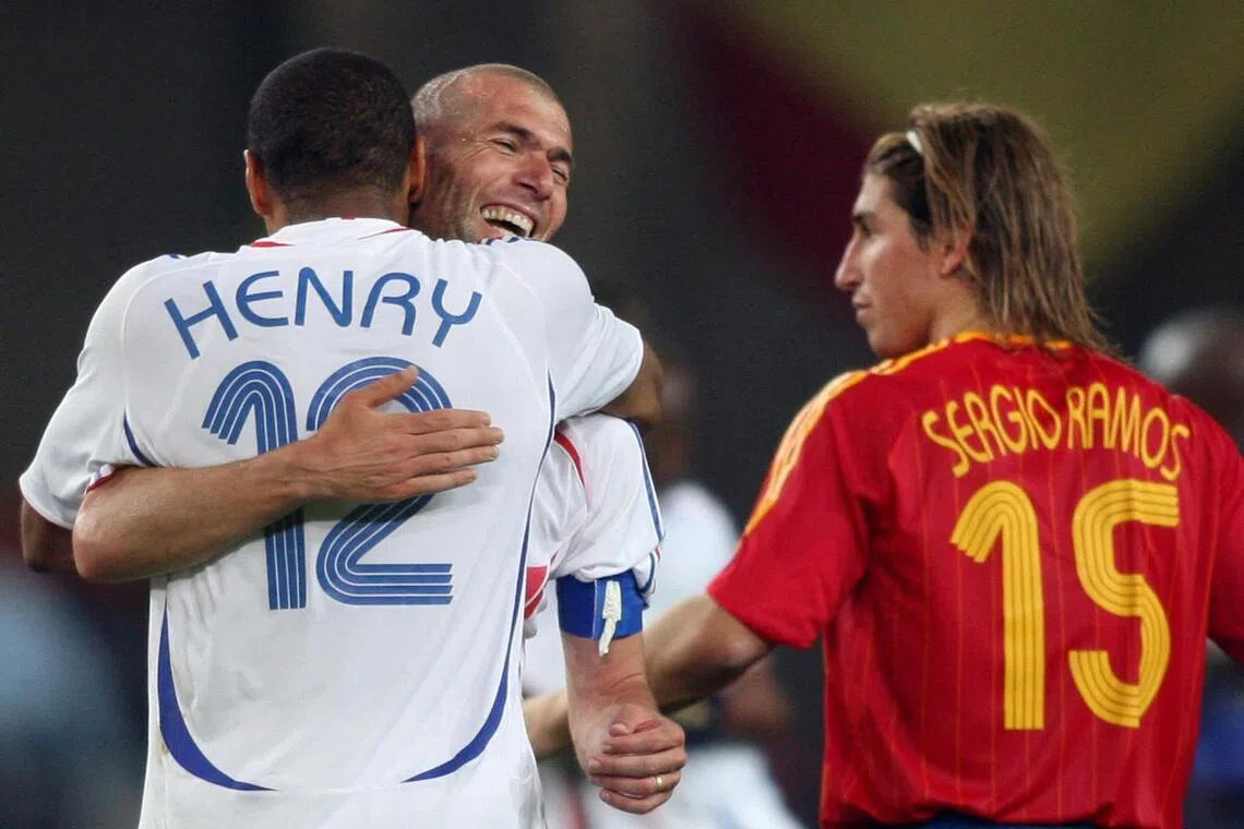 (FILES) French forward Thierry Henry (L) and teammate midfielder Zinedine Zidane (C) celebrate next to Spanish defender Sergio Ramos (R) at the end of the World Cup 2006 round of 16 football game Spain vs. France, on June 27, 2006 at Hanover stadium. (Photo by Patrik STOLLARZ / AFP)
