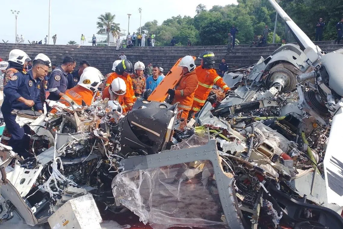 Emergency personnel work at the site where two helicopters collided in the western Malaysian state of Perak.