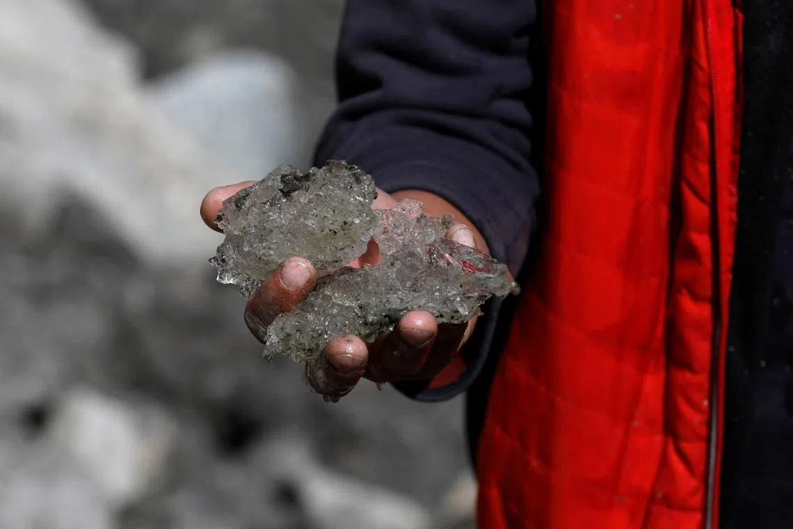 Tariq Jamil, 51, chairman of the Community Based Disaster Risk Management Centre, posing with ice taken from the Shisper glacier, near Hassanabad village, Hunza valley, in the Karakoram mountain range in the Gilgit-Baltistan region of Pakistan, Oct 10, 2023. 