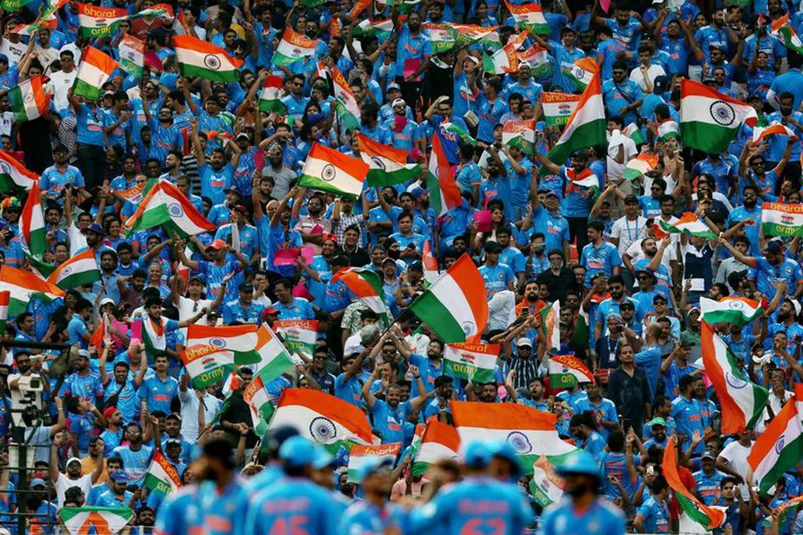 Cricket - ICC Cricket World Cup 2023 - India v Pakistan - Narendra Modi Stadium, Ahmedabad, India - October 14, 2023 India fans in the stands celebrate after third umpire confirm the wicket of Pakistan's Saud Shakeel, lbw bowled by India's Kuldeep Yadav after the DRS review    REUTERS/Amit Dave